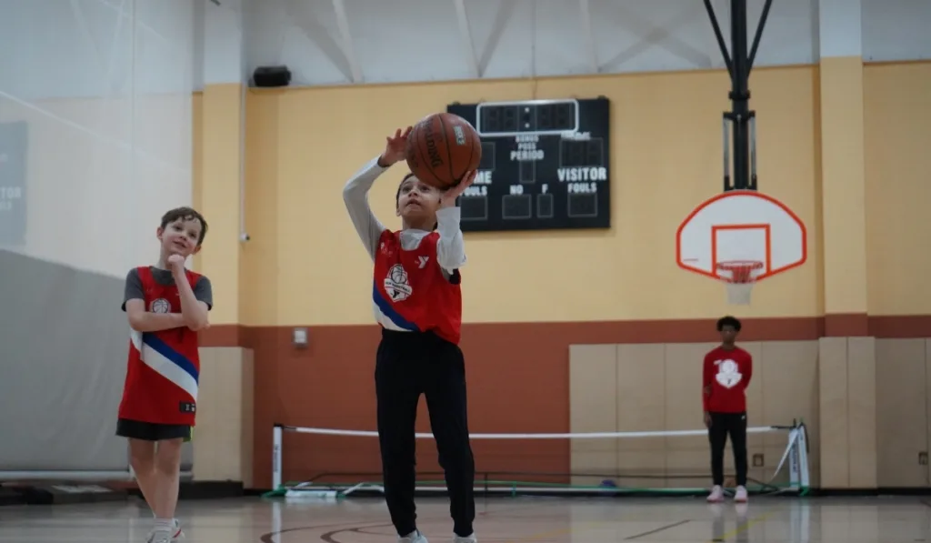 Children playing basketball inside gymnasium at Boyertown Y