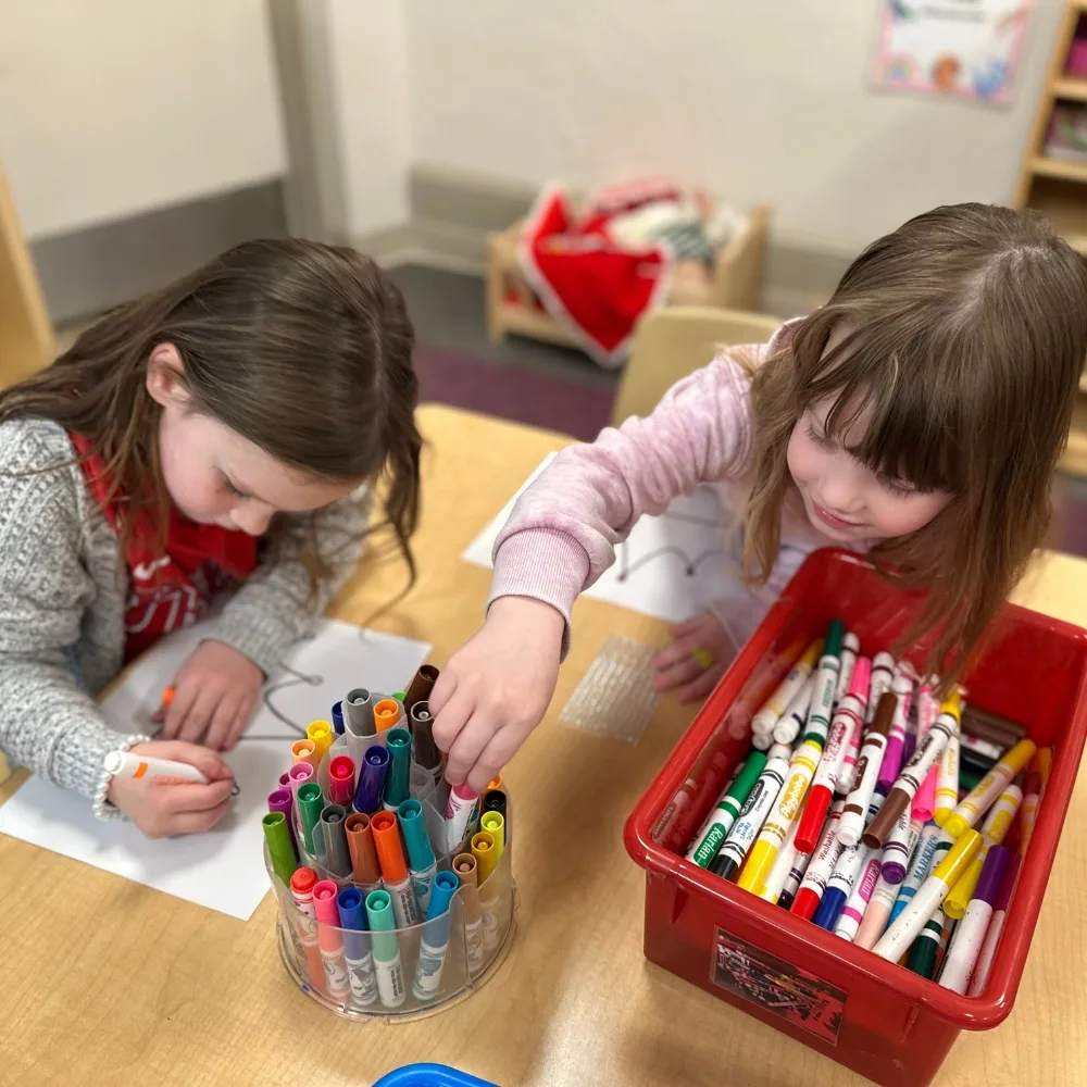 Children coloring on paper inside classroom at Briggs Early Learning Center