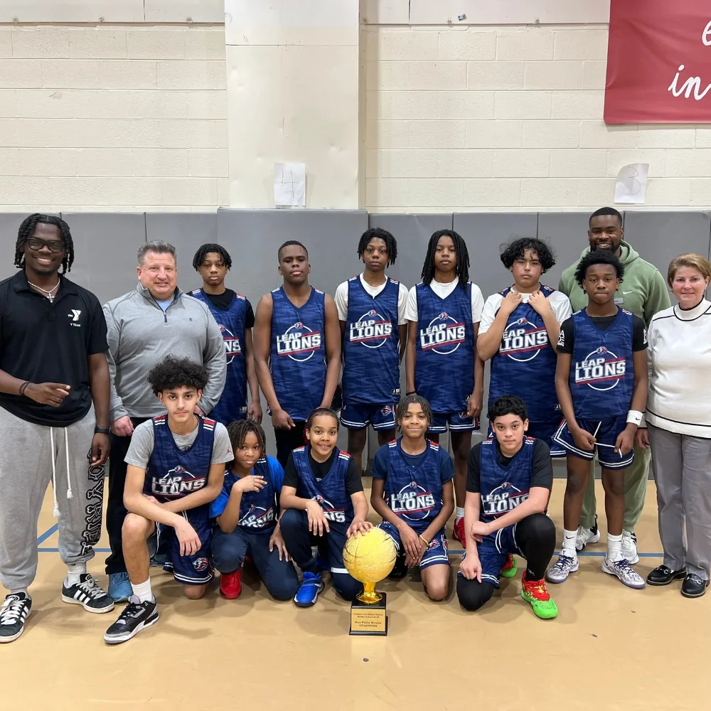 Youth Camden Basketball team with trophy at indoor gymnasium