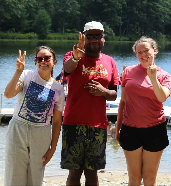 Camp counselors smiling outdoors at Camp Speers