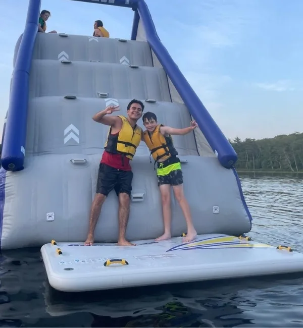 Camp counselor and camper on lake inflatable at Camp Speers