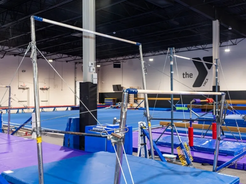 Uneven bars and mats inside Haverford Y's Gymnastics Center