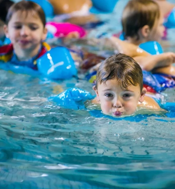 Children swimming inside indoor pool
