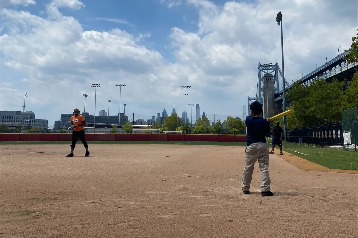 Children playing baseball on baseball diamond outdoors during Camden Y's CATCH program