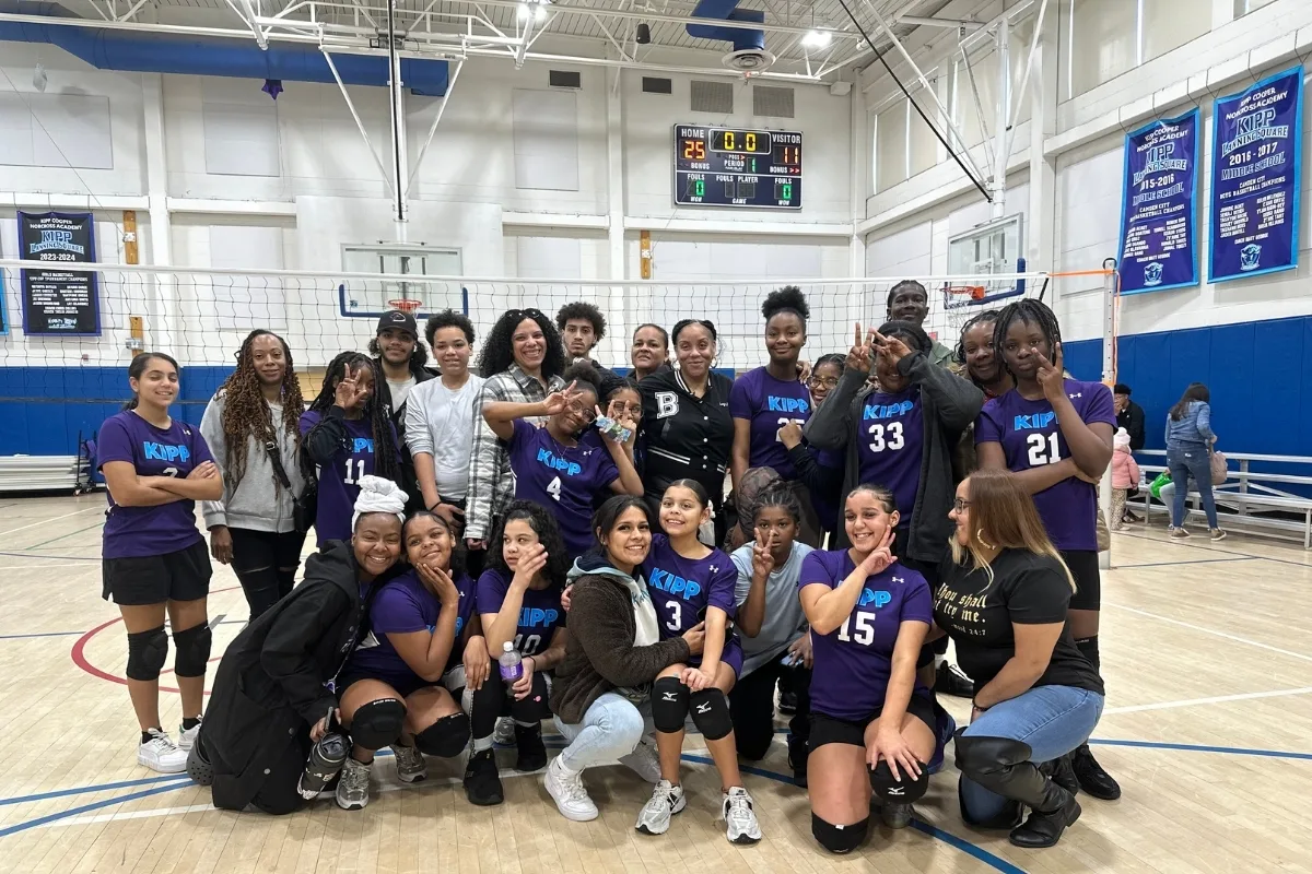 Youth Camden Community Volleyball team with parents at volleyball game inside gymnasium