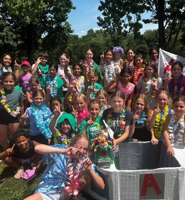 Group of campers posing with duct tape raft outdoors