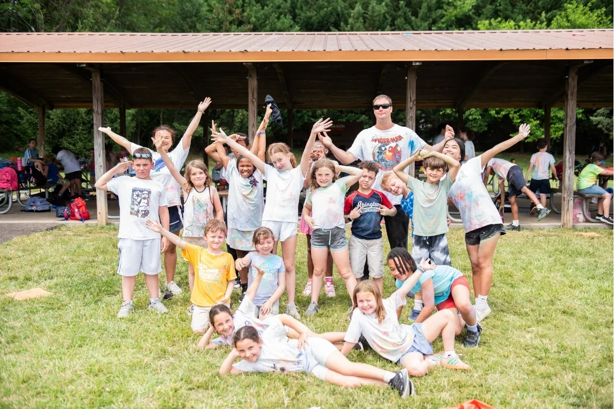 Group of campers with camp counselor posing outside