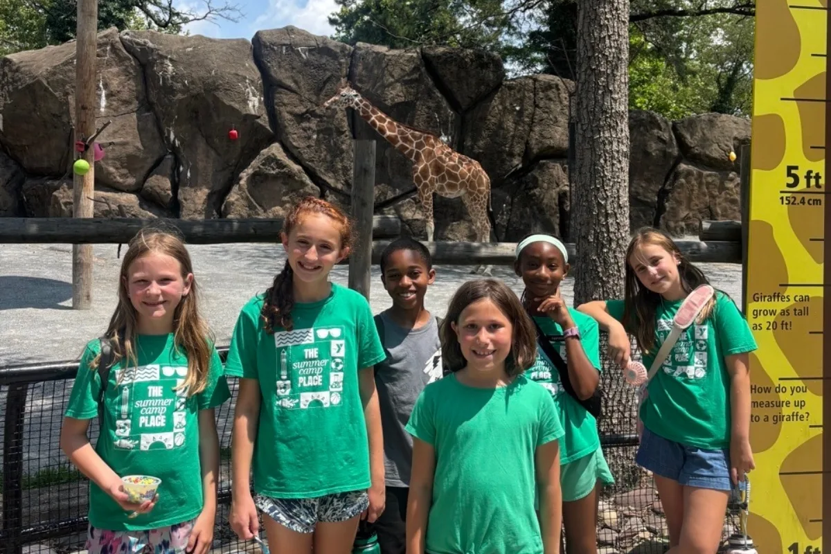 Group of campers posing at a giraffe enclosure