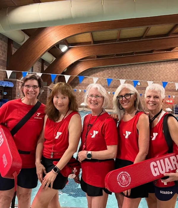Group of lifeguards posing in front of an indoor pool