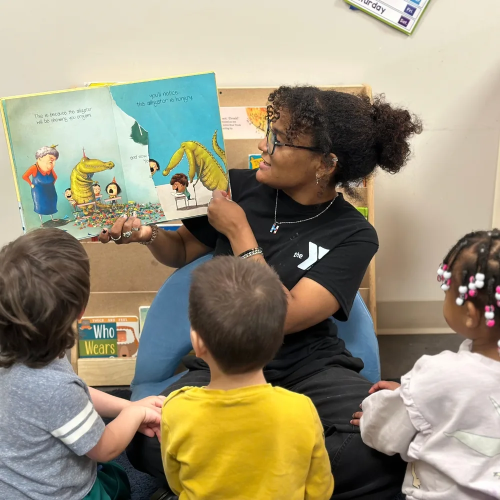 Early Learning Center staff member reading to a group of children in a classroom