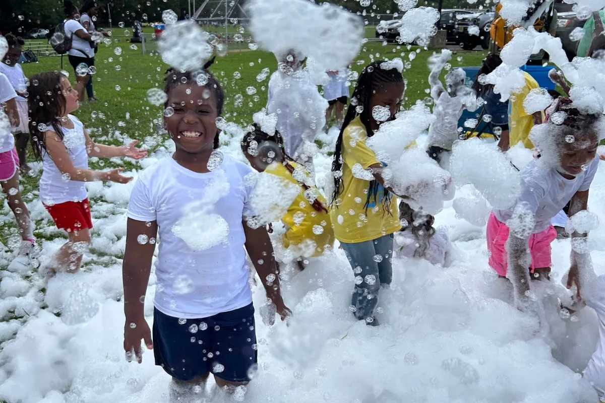 Campers playing with foam outdoors at Christian Street Y's summer camp