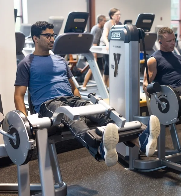 Member using leg exercise machine at fitness center