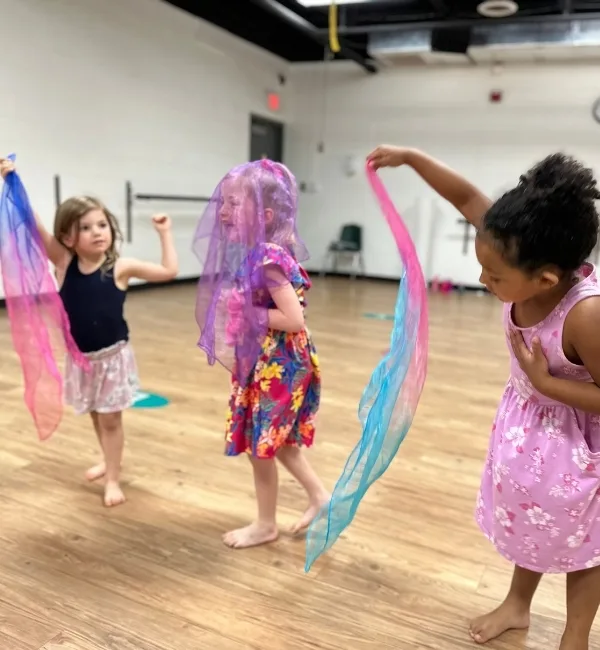 Youth dancers practicing with silks in a studio