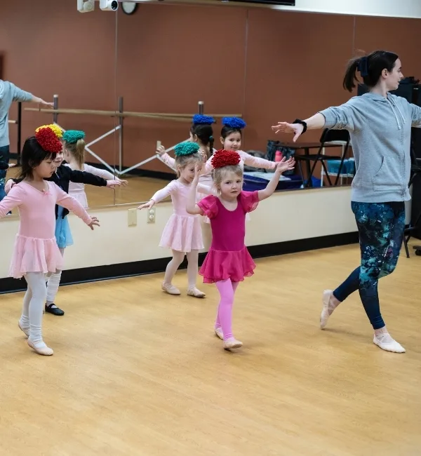 Youth dancers practicing with dance instructor in a studio