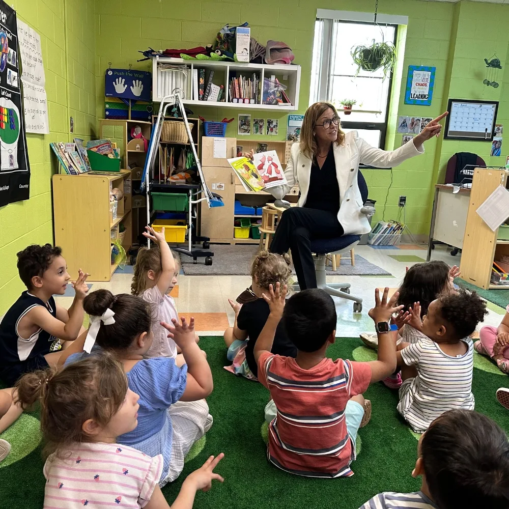 Early Learning Center staff member reading to a group of children in a classroom