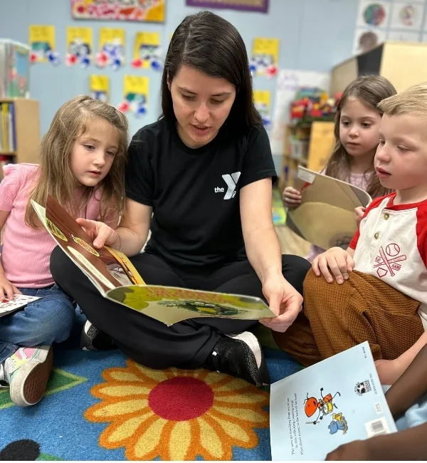 Early Learning Center staff member reading to a group of children in a classroom