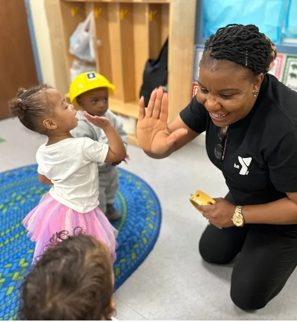 Early Learning Center staff member playing with children in a classroom