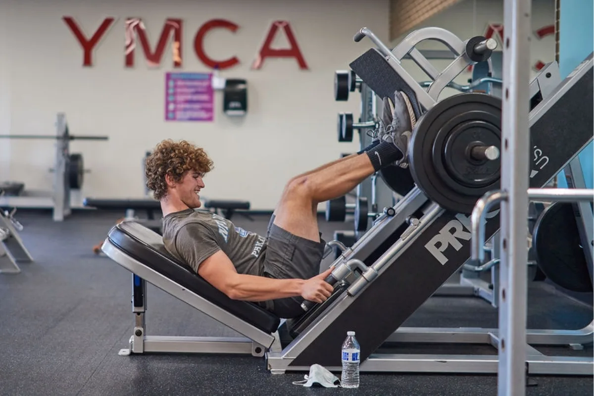 Member doing leg presses on leg press machine inside fitness center