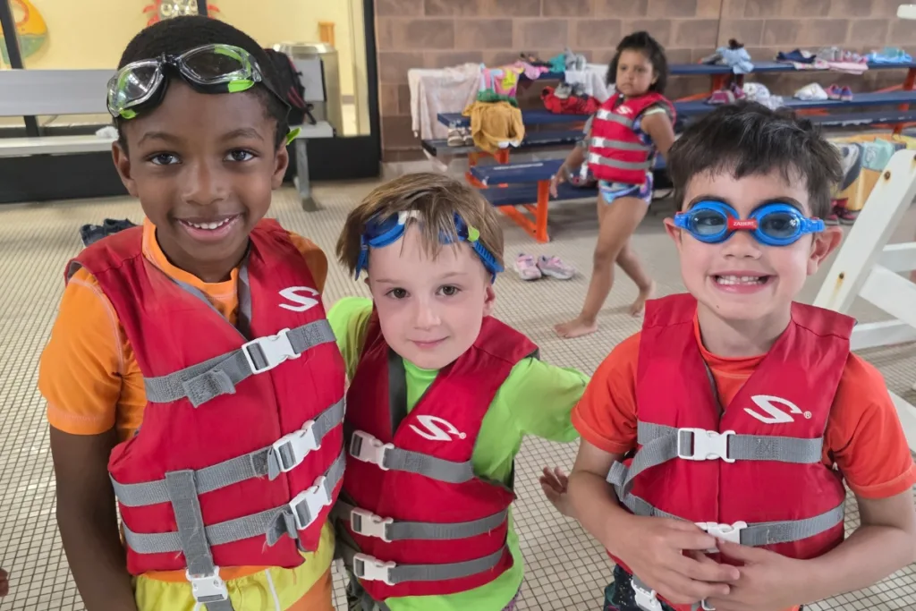Children wearing swim gear inside indoor pool