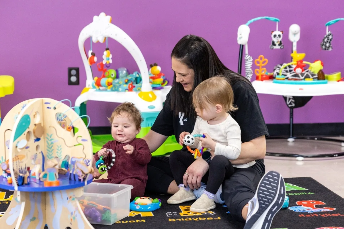 Y staff member playing with young children in KidZone area