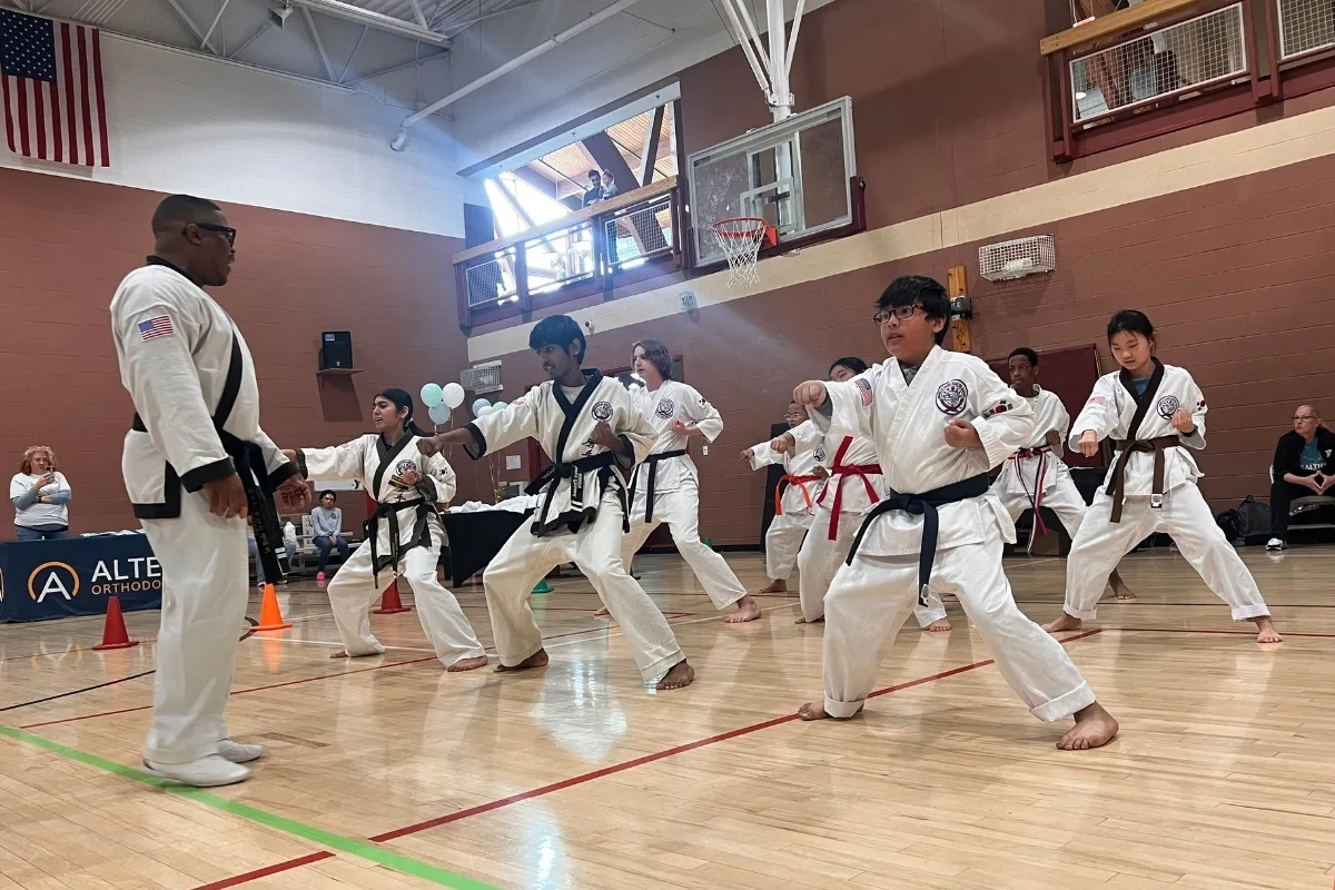 Youth practicing martial arts with coach inside gymnasium