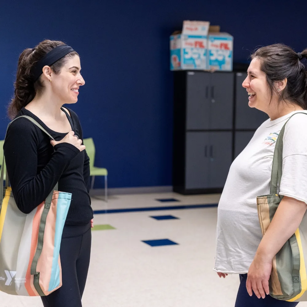Trainer speaking to pregnant member during Maternal Wellness meeting