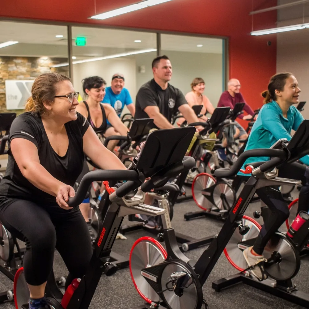 Group exercise cycling class inside studio