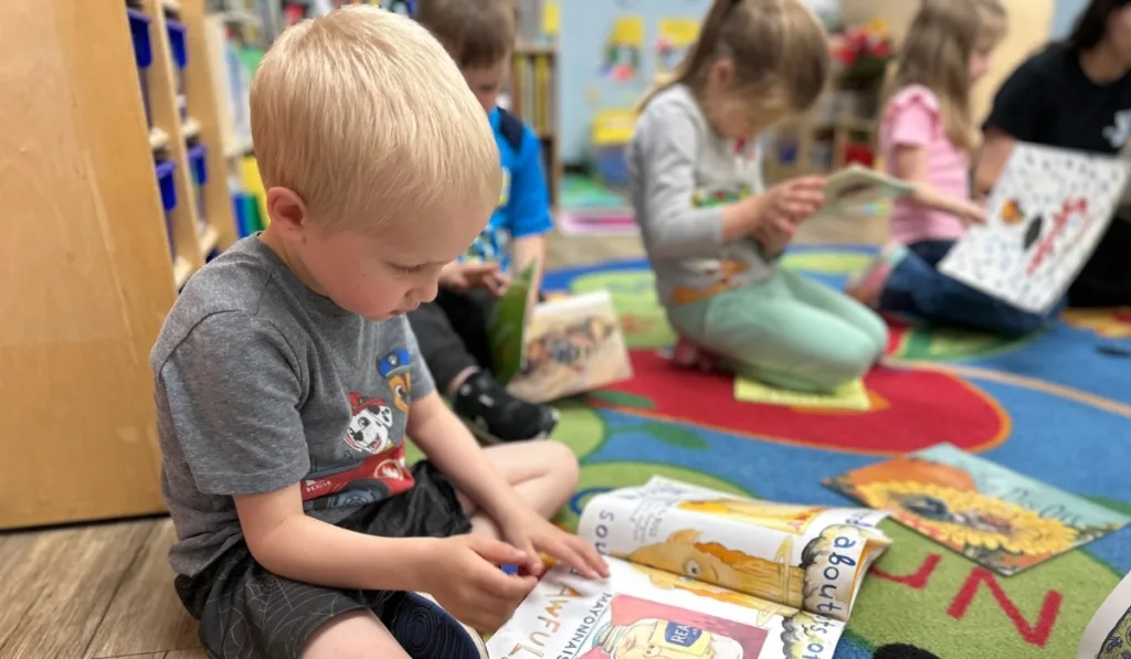 Children reading books inside classroom