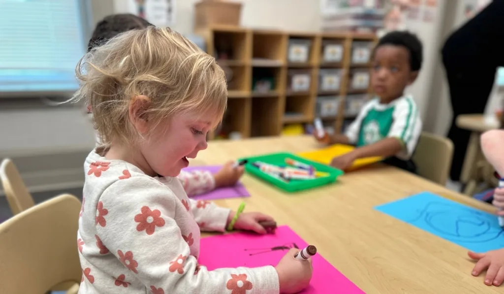 Children drawing on table inside classroom