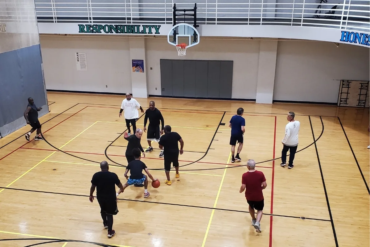 Members playing basketball inside gymnasium