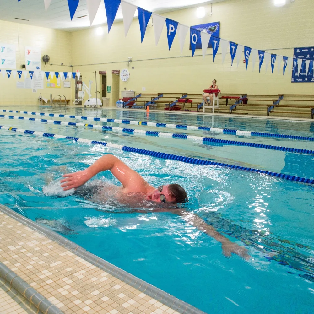 Member doing swim strokes inside indoor pool