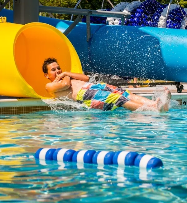 Child on outdoor pool slide at Upper Perkiomen Valley Y