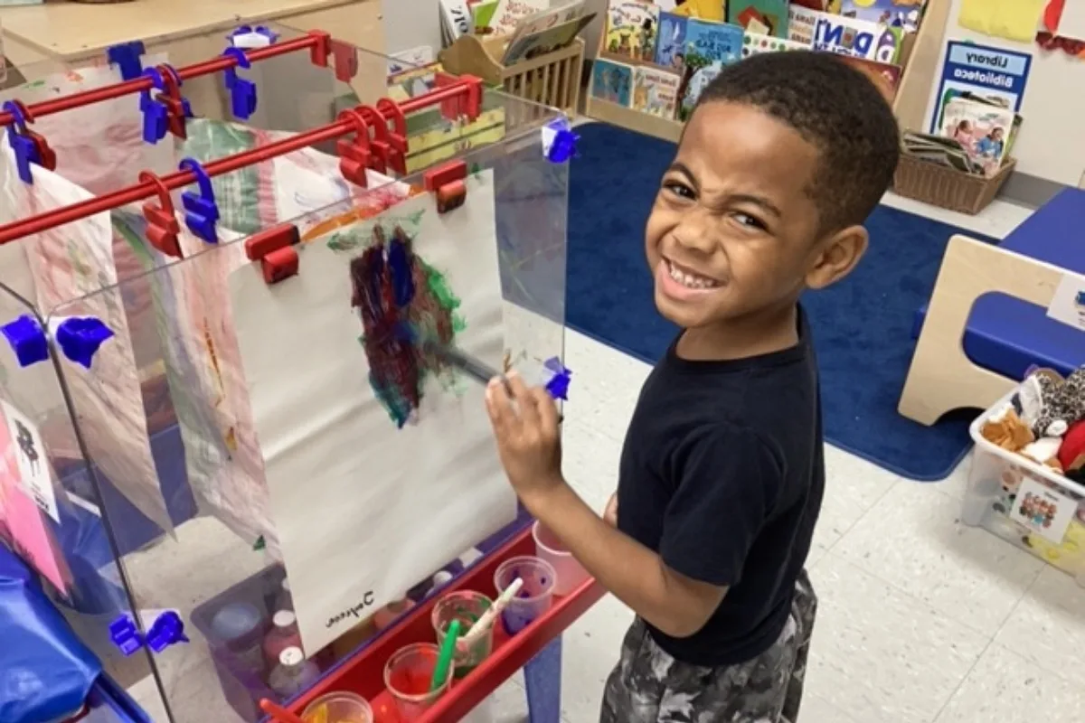 Child painting in classroom