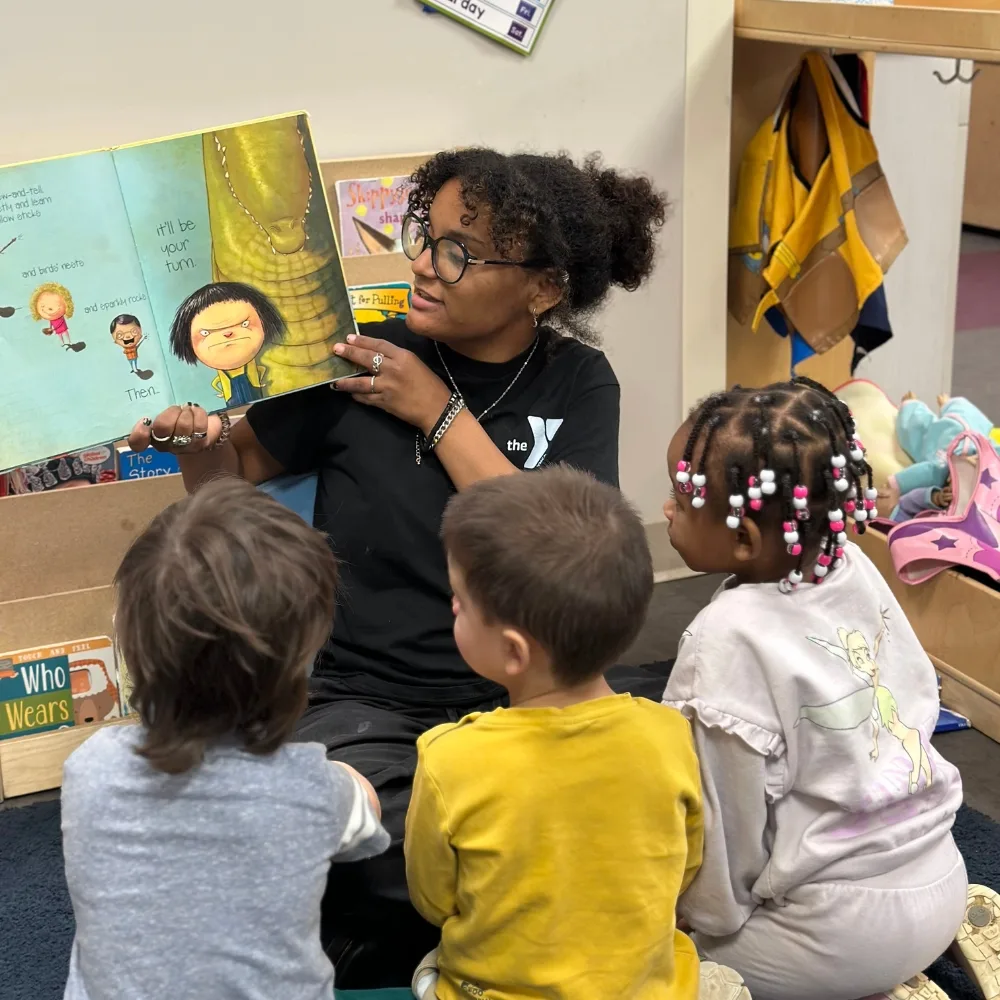 Pre-K staff member reading to a group of children in a classroom