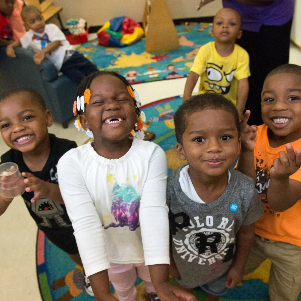 Group of children smiling in a classroom