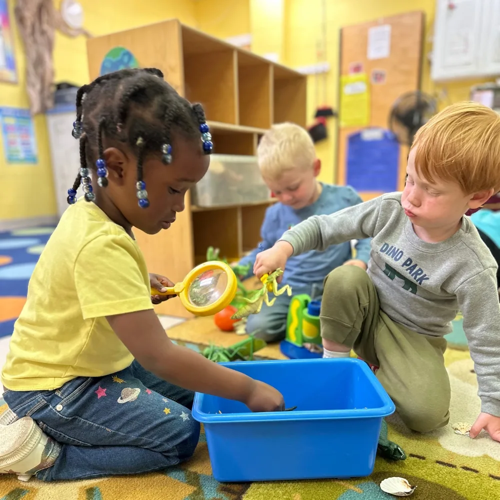Children playing with toys on the ground in classroom