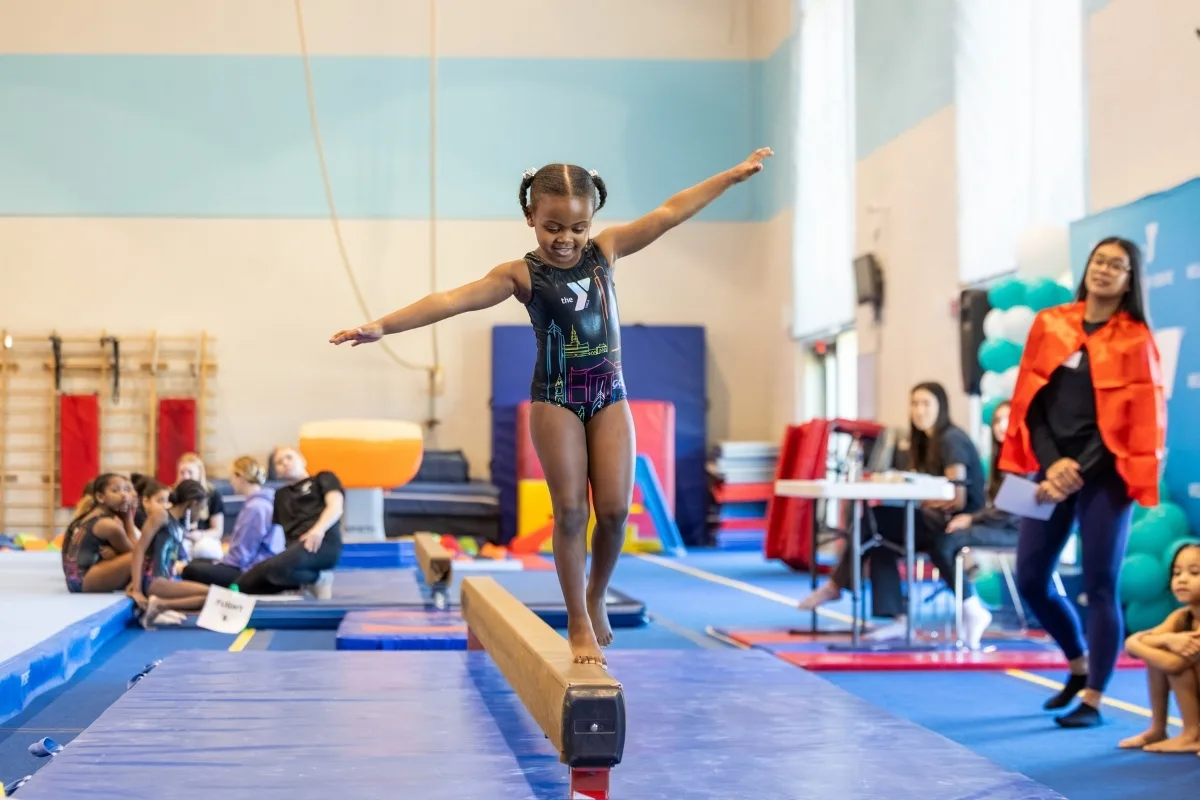 Child balancing on balance beam at indoor gymnastic facility