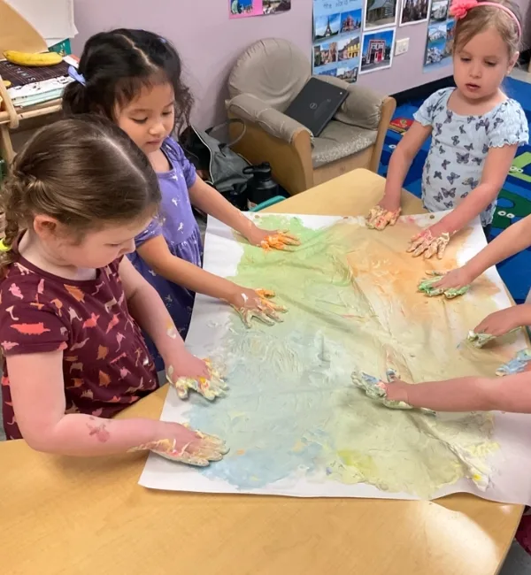 Children playing with paint in a classroom