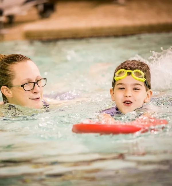 Child learning to swim in indoor pool