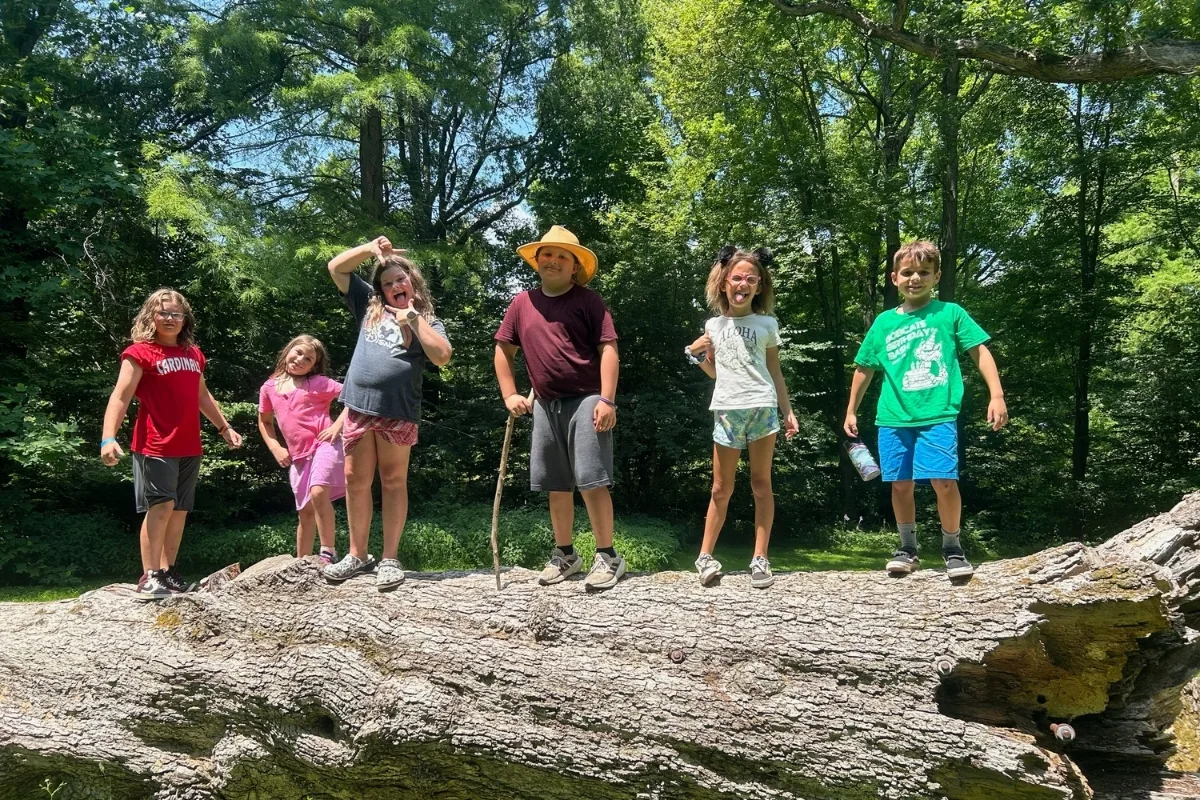 Rocky Run Y's summer campers standing on a log outdoors