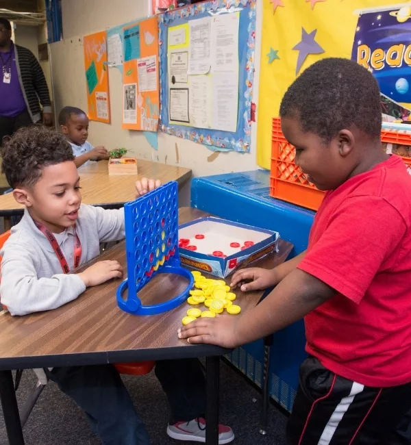 Children playing board game in classroom