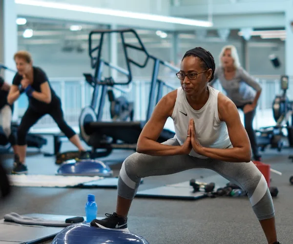 Small group exercise class with balance equipment and weights inside a studio