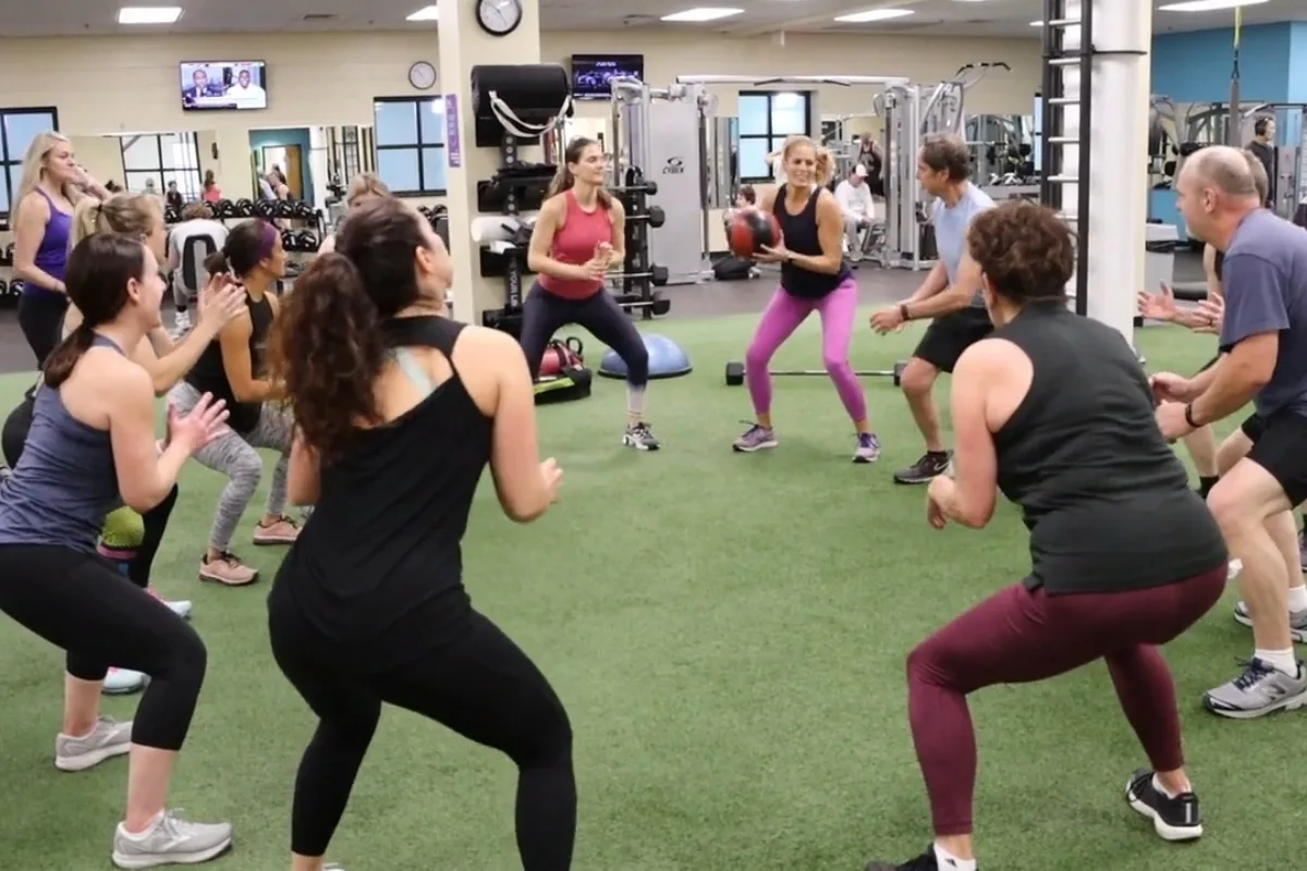 Small group exercise on turf area inside a fitness center