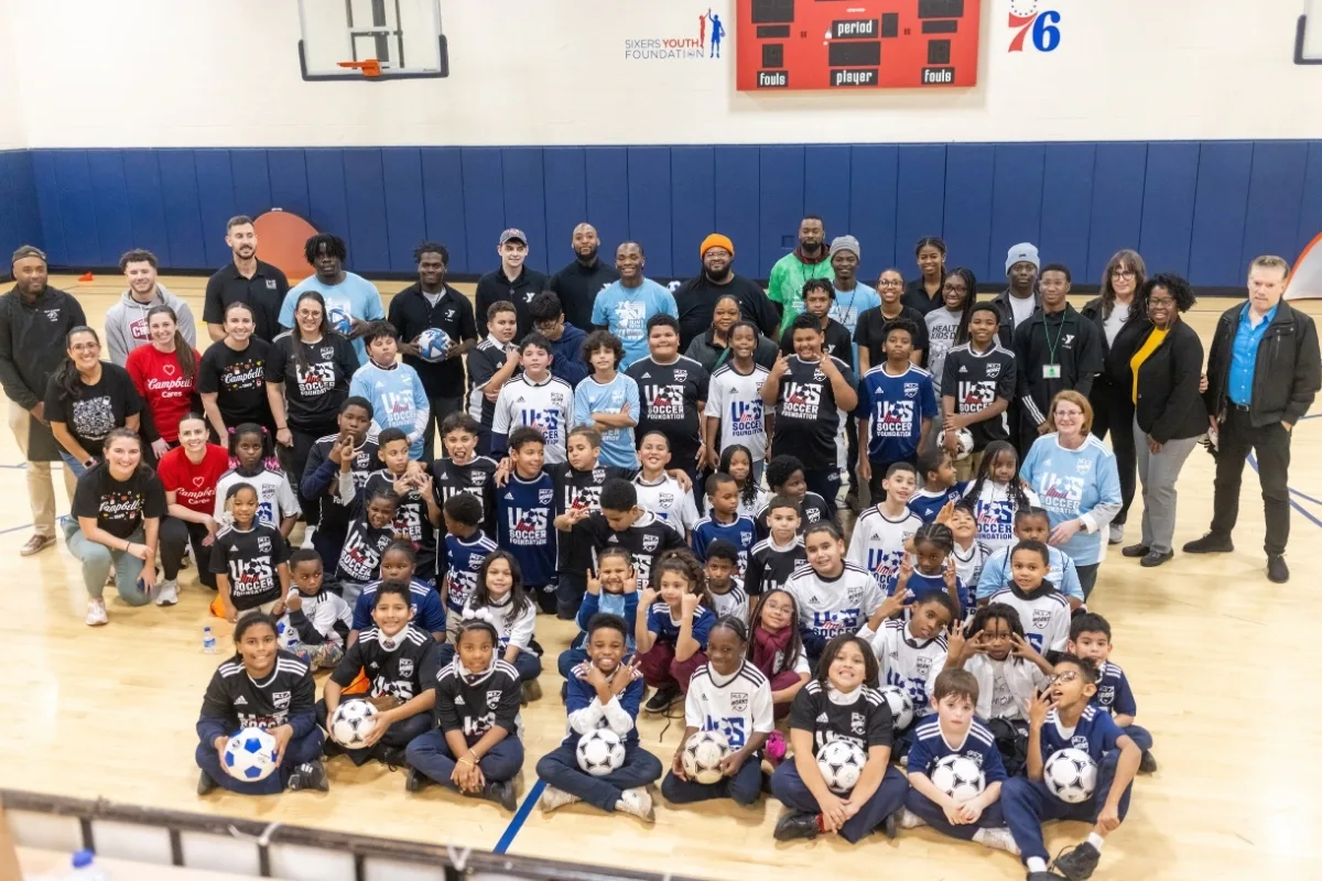 Youth athletes and coaches at Soccer for Success soccer clinic inside gymnasium