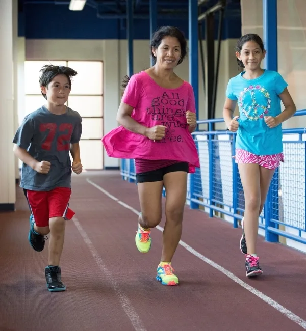 A family running on an indoor track