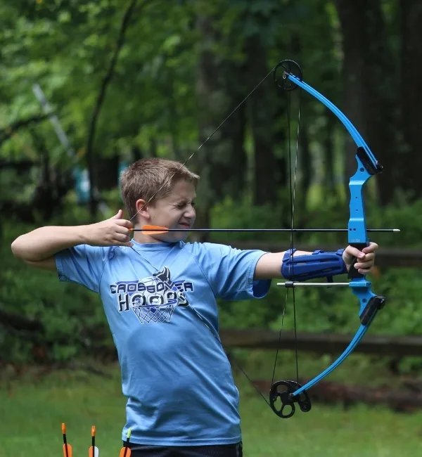 Child shooting a bow outdoors