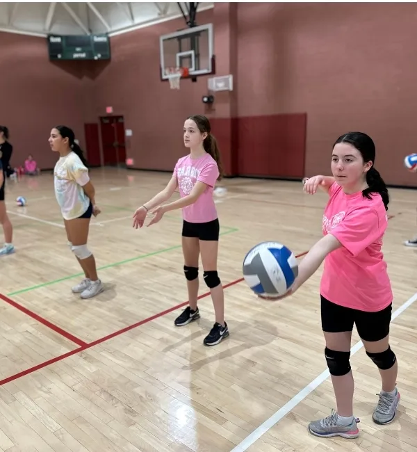 Youth practicing volleyball in a gymnasium