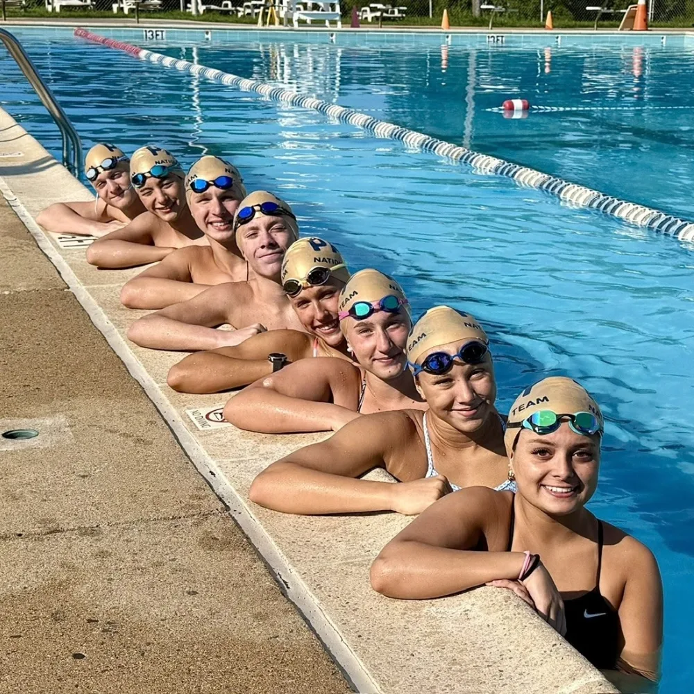 Swim team posing inside outdoor pool
