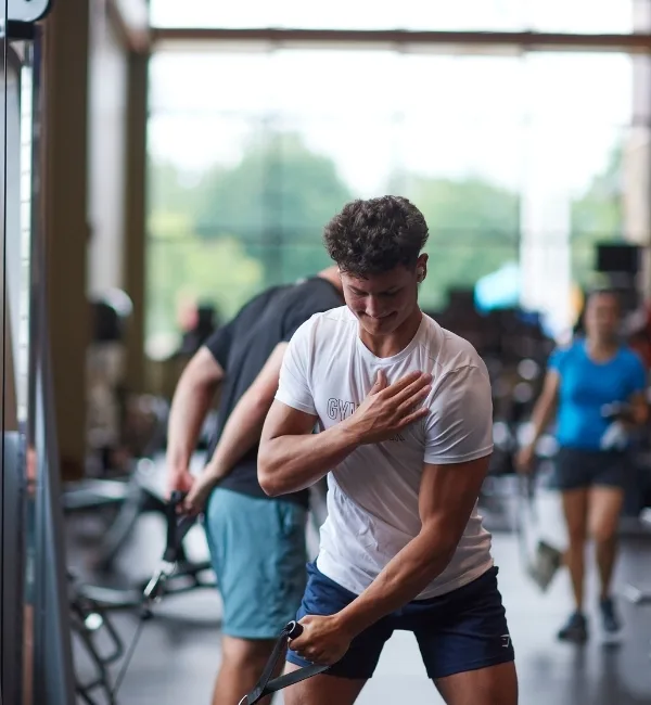 Member using pulling machine inside fitness center