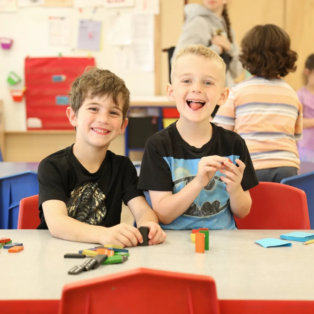 Children playing with dominoes inside classroom